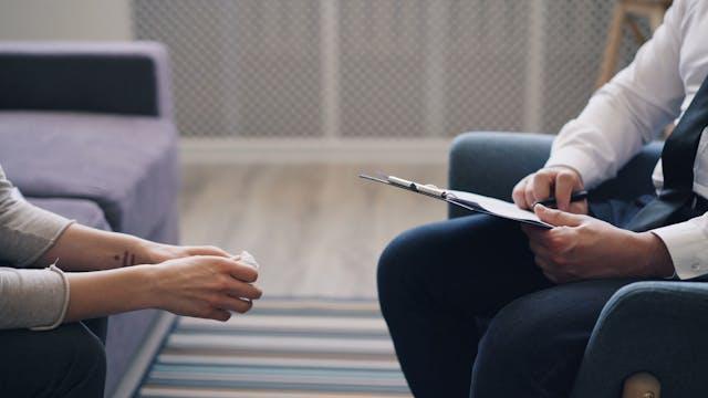 Two people sitting with clipboard